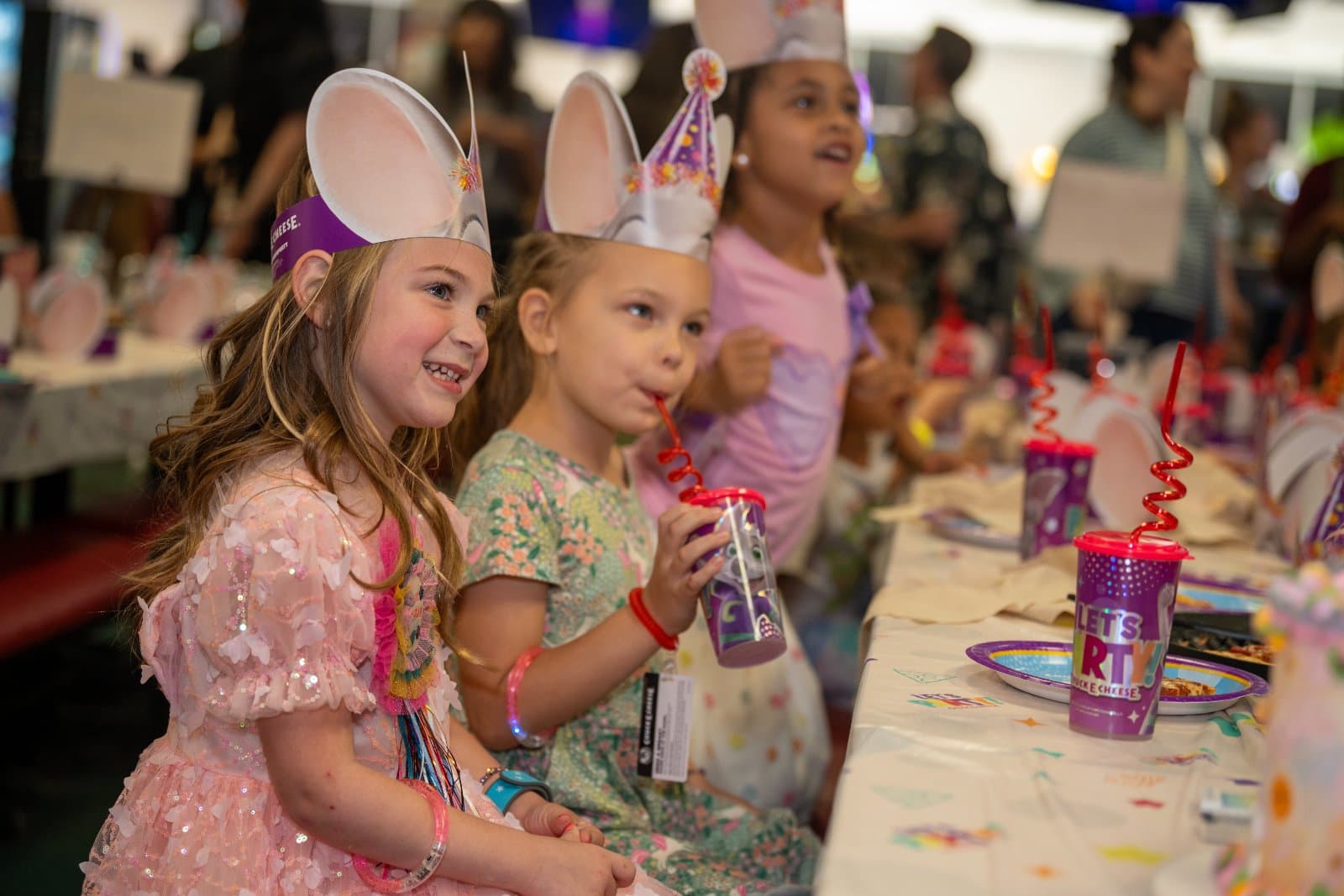 Children sitting at a decorated party table wearing themed hats and enjoying a fun birthday celebration — photographed by Zan Visuals.